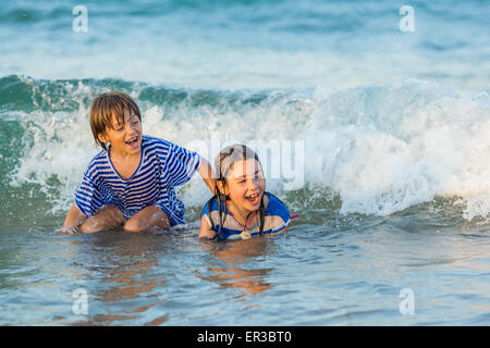 Deux enfants heureux jouant dans la mer Banque D'Images