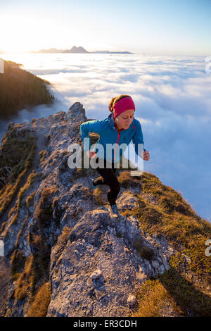 Jeune femme qui court le long d'une crête de montagne, Salzbourg, Autriche Banque D'Images