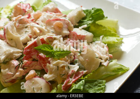 Salade de fruits de mer à la mayonnaise avec les crevettes et la chair de crabe et de l'aneth frais, laitue romaine, et garnir de feuilles de basilic Banque D'Images