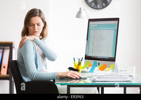 Femme au travail souffrent de la douleur de l'épaule. Banque D'Images