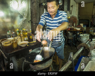 Bangkok, Bangkok, Thaïlande. 26 mai, 2015. Un homme fait un ordre de Pad Thaï (nouilles frites) à son petit restaurant sur Sukhumvit Soi 38 à Bangkok. Il a eu le restaurant depuis plus de 30 ans et a de fermer dans les prochains mois. Les chariots et les petits restaurants le long de Soi 38 ont été populaires auprès des touristes et les thaïlandais pour plus de 40 ans. La famille qui est propriétaire du terrain le long de la di a récemment décidé de vendre à un promoteur de condominiums et de ne pas renouveler les baux des propriétaires de restaurant. Plus de 40 restaurants et de chariots devront fermer. La première vague de fermetures pourrait commencer comme Banque D'Images