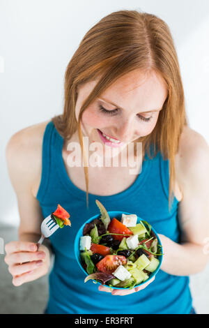 Femme mangeant une salade méditerranéenne. Banque D'Images