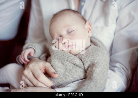 Bébé dort sur les genoux de sa mère, cropped Banque D'Images