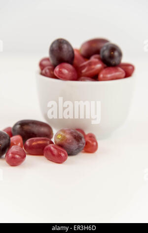 Les raisins de pourpre violet vs jelly beans - snack-décision entre aliments sains ou junk food Banque D'Images