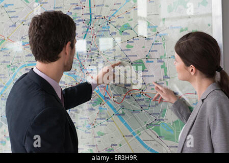 L'homme et la femme regarder Paris Plan du métro de concert Banque D'Images