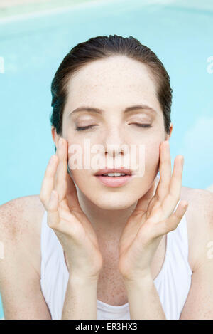 Young woman touching her face, eyes closed Banque D'Images