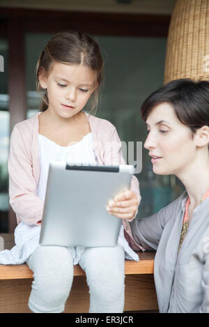Mère et fille using digital tablet Banque D'Images