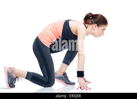 Vue latérale d'un coureur portrait femme sportive en position démarrage isolé sur fond blanc Banque D'Images