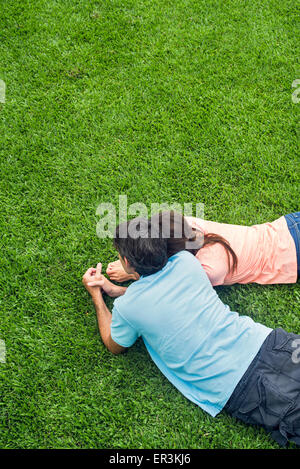 Couple lying together on grass Banque D'Images