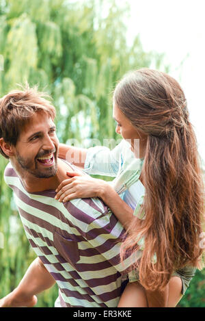 Young man giving girlfriend piggyback ride Banque D'Images