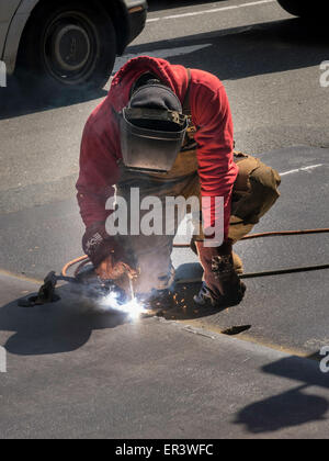 Soudure sur la plaque en acier travailleur street, NYC Banque D'Images