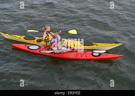 Merrick du sud, New York, USA. 24 mai 2015. Un jeune homme et femme sont kayak en Merrick Bay le long de la rive sud du parc de prélèvement et conservation au cours du week-end du Memorial Day. Le kayak rouge et jaune Caroline avait kayak avait écrit sur Montauk leurs arcs. Banque D'Images