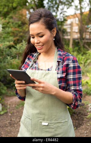 Jeune femme dans le jardin avec sa tablet Banque D'Images