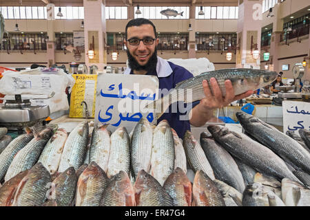 L'homme tenant un poisson pour la vente à la criée à Souq Sharq à Koweït City, Koweït. Banque D'Images