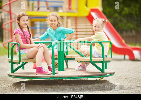 Friendly filles équitation sur carousel au lieu de loisirs Banque D'Images