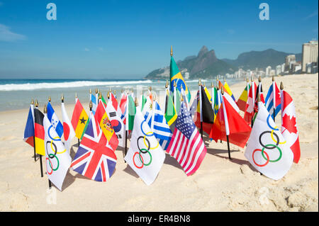 RIO DE JANEIRO, Brésil - 20 mars 2015 : drapeaux olympiques volent ensemble avec un tableau du Brésil et international les drapeaux sur le sable. Banque D'Images