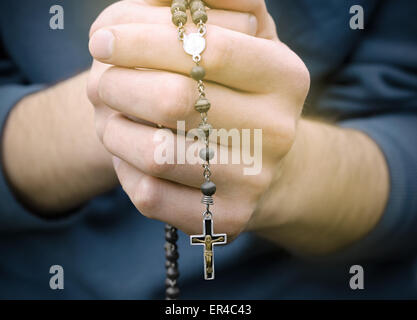 L'homme prie avec un chapelet dans les mains Banque D'Images