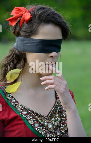 Femme avec un bandeau sur champ vert Banque D'Images