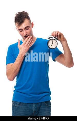 Jeune homme posant avec un réveil Banque D'Images