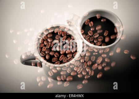 Deux tasses de café blanc debout sur une table sur les grains de café rouillé foncé texture. Double exposition photo avec photo style vintage fil Banque D'Images