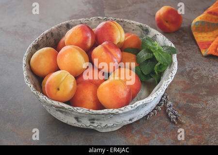 Les abricots. Bol d'abricots récoltés sur une surface en pierre rustique, vue du dessus, style rustique. La lumière naturelle Banque D'Images