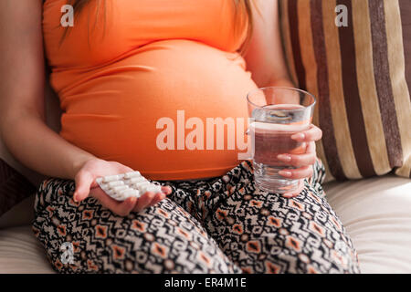 Femme enceinte de prendre une pilule. Debica, Pologne Banque D'Images