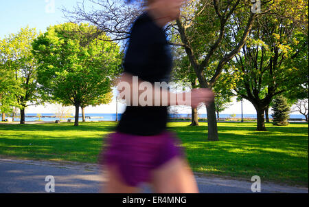 Flou de mouvement et méconnaissable section centrale de corps féminin s'exécutant sur waterfront trail près de la baie Humber à Toronto Banque D'Images