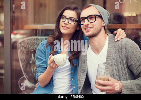 Mode jeune couple drinking coffee à l'extérieur du café. Cracovie, Pologne Banque D'Images