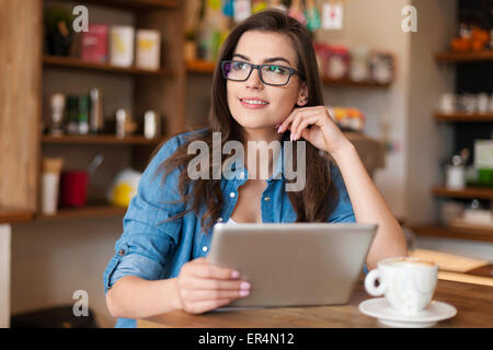 Young woman using digital tablet at cafe. Cracovie, Pologne Banque D'Images