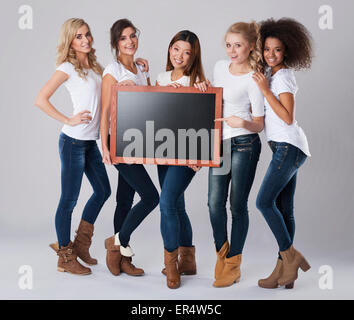 Jolies filles avec tableau noir vide. Debica, Pologne Banque D'Images