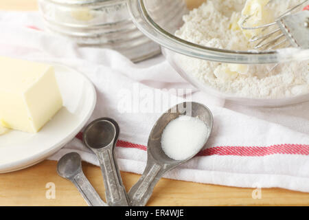 Bol à mélanger avec la farine et le beurre, vintage tamis, cuillères à mesurer et linges à vaisselle Banque D'Images