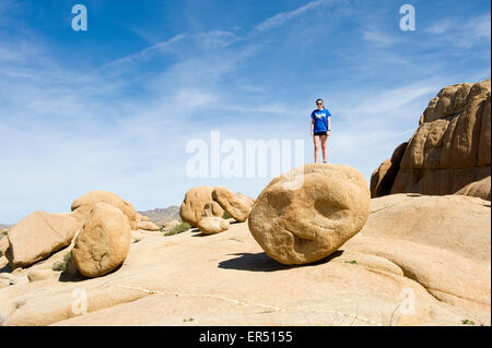 Paysage du désert de Mojave avec fille debout sur un grand rocher rond,Souther California, USA. Banque D'Images