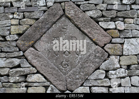 Date de 1689 avec une histoire intéressante en pierre construit dans un mur près de Wirksworth Banque D'Images