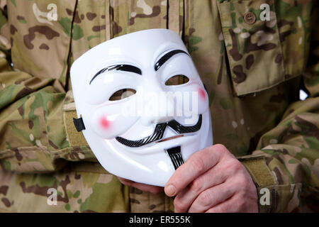 L'homme à lutter contre les fatigues holding Guy Fawkes utilisé masqués par le piratage groupe anonymous Banque D'Images