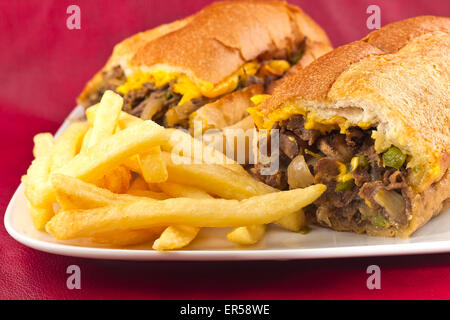 Un sale Philly Cheesesteak avec oignons poivrons et champignons, frites sur le côté Banque D'Images