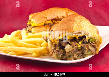 Un sale Philly Cheesesteak avec oignons poivrons et champignons, frites sur le côté Banque D'Images