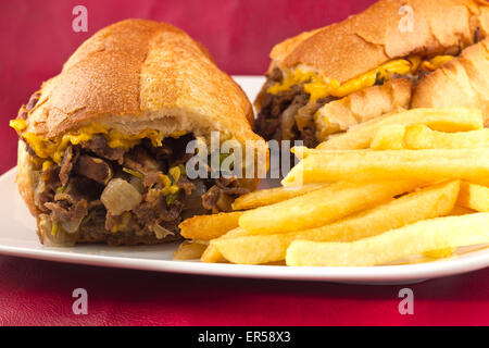 Un sale Philly Cheesesteak avec oignons poivrons et champignons, frites sur le côté Banque D'Images