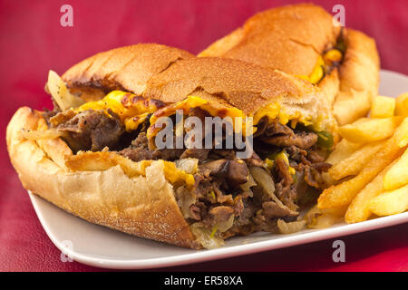 Un sale Philly Cheesesteak avec oignons poivrons et champignons, frites sur le côté Banque D'Images