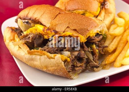 Un sale Philly Cheesesteak avec oignons poivrons et champignons, frites sur le côté Banque D'Images