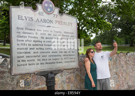 Memphis, Tennessee - un couple prend un mur qui entoure l'extérieur selfies Elvis Presley's Graceland Mansion. Banque D'Images