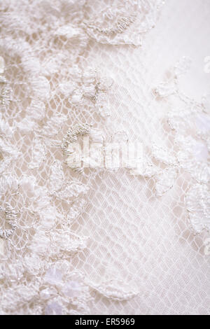 Close up de détail sur une dentelle robe de mariage de rétroéclairage. Banque D'Images