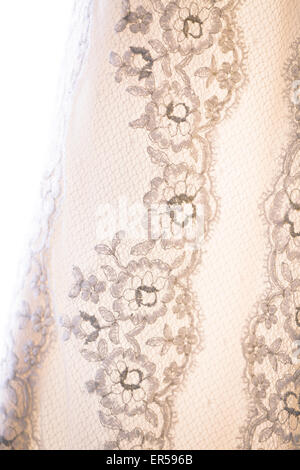 Close up de détail sur une dentelle robe de mariage de rétroéclairage. Banque D'Images