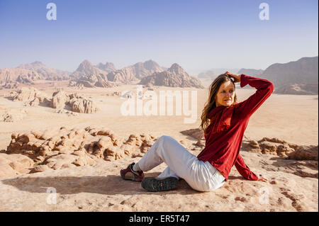 Femme reposant sur un rocher, Wadi Rum, Jordanie, Moyen-Orient Banque D'Images