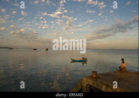 L'enfant assis sur la jetée, Sittwe, Akyab, bateau de pêche avec des pêcheurs dans le port, Rakhaing State, l'Arakan, Myanmar, Banque D'Images