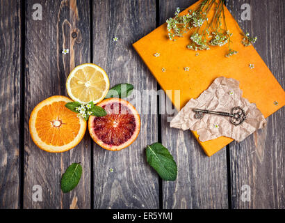 Les oranges, citron, jaune, portable et clés fleurs blanches à fond de bois Banque D'Images