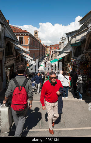Venise, Italie - 24 avril 2013 : les touristes et les habitants de monter les marches du Pont Rialto entre les rangées d'étals. Banque D'Images