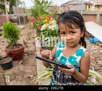 Petite fille jouant avec un ordinateur tablette, Phnom Penh, Cambodge Banque D'Images