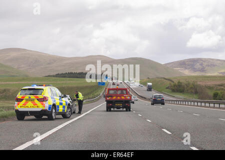 Automobiliste intercepté par le côté de l'autoroute M74 en direction sud par un agent de police dans l'auto-patrouille - Écosse, Royaume-Uni Banque D'Images