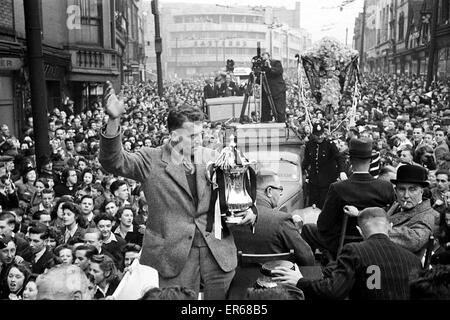 L'équipe de Derby County retour à la maison avec le trophée de la FA Cup après leur victoire contre Charlton Athletic en finale à Wembley. Photo montre : Derby le capitaine Jack Nicholas montrant off il trophée. 1er mai 1946. Banque D'Images