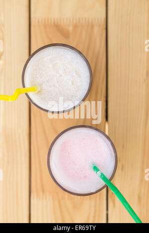 Deux verres de lait secouer avec paille sur table en bois. Voir l'image haut de page Banque D'Images